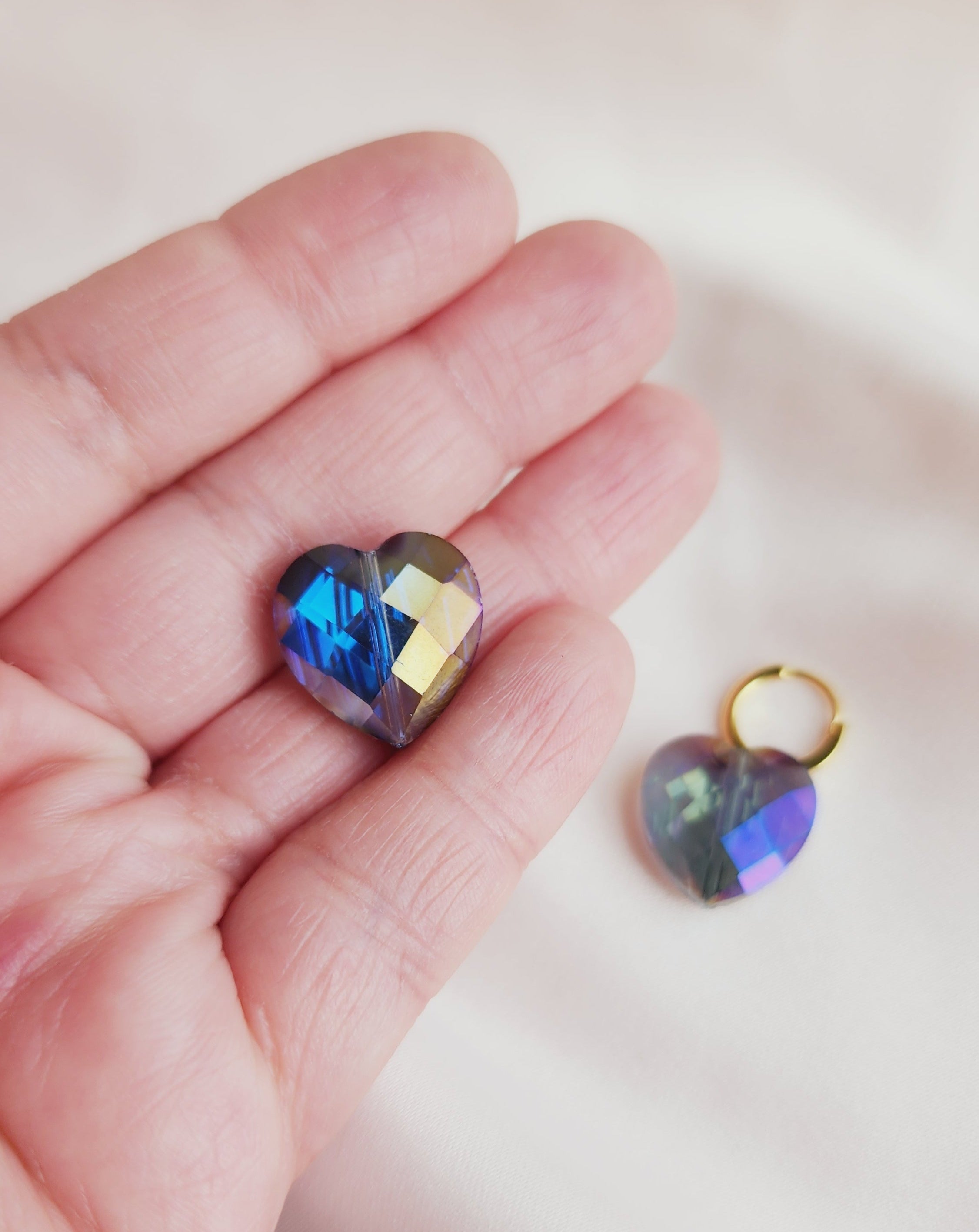 iridescent heart hoops in my hand for size reference