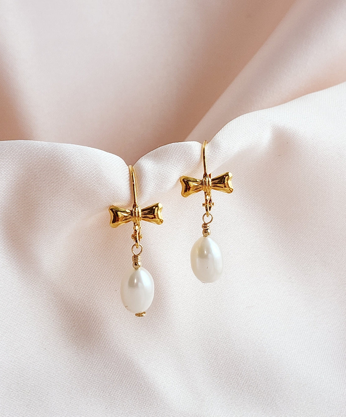 Front View of a pair of bow leverback earrings with teardrop pearls 