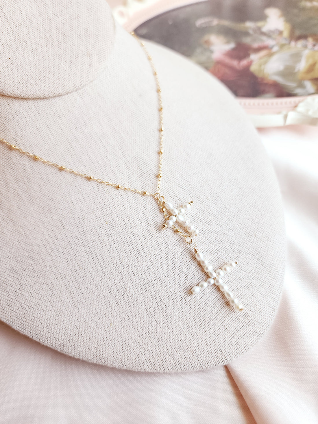 Top view of a lariat necklace with handmade pearl crosses dangling in the center, perfect necklace for everyday and bridal 