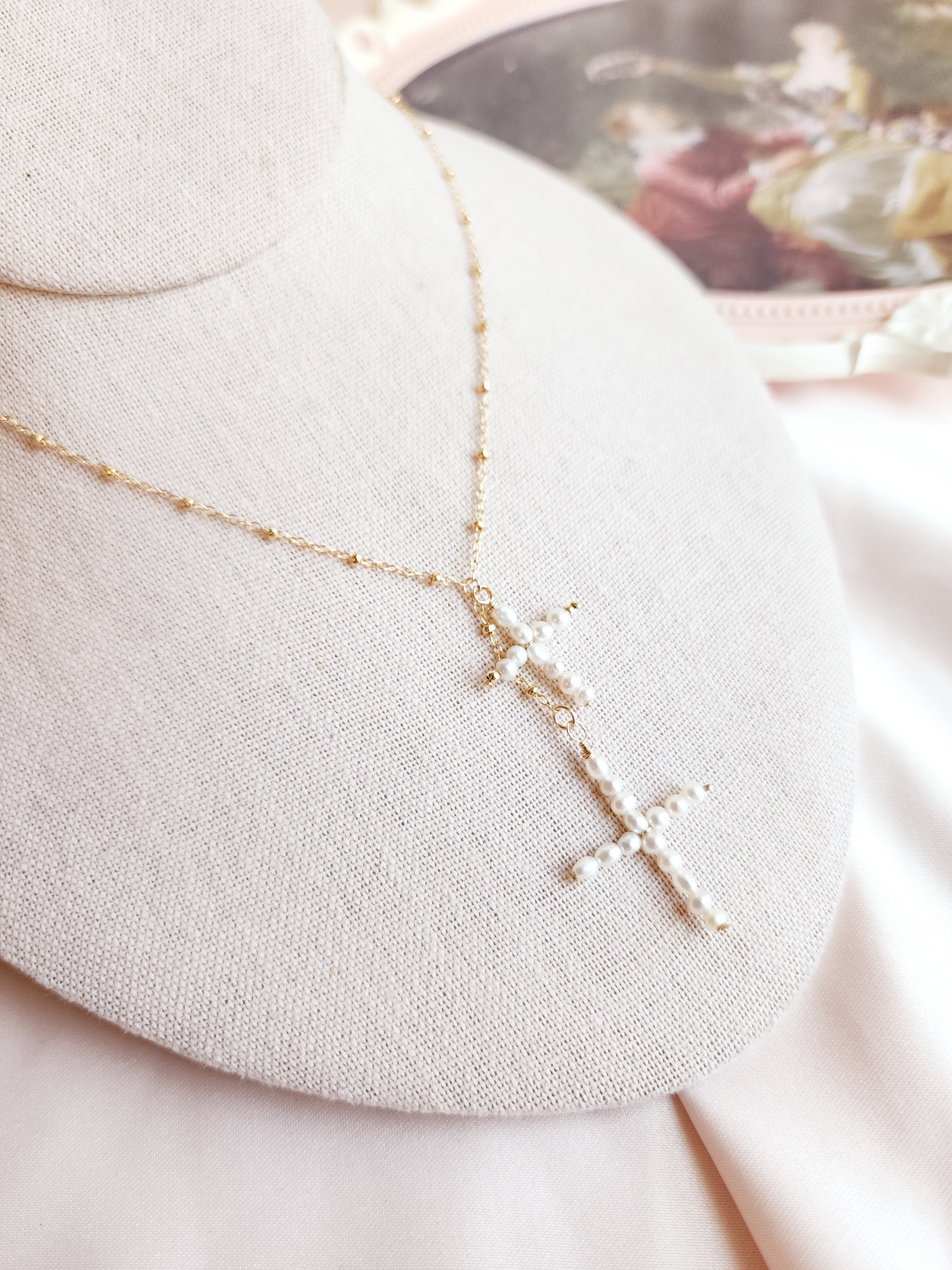 Top view of a lariat necklace with handmade pearl crosses dangling in the center, perfect necklace for everyday and bridal 