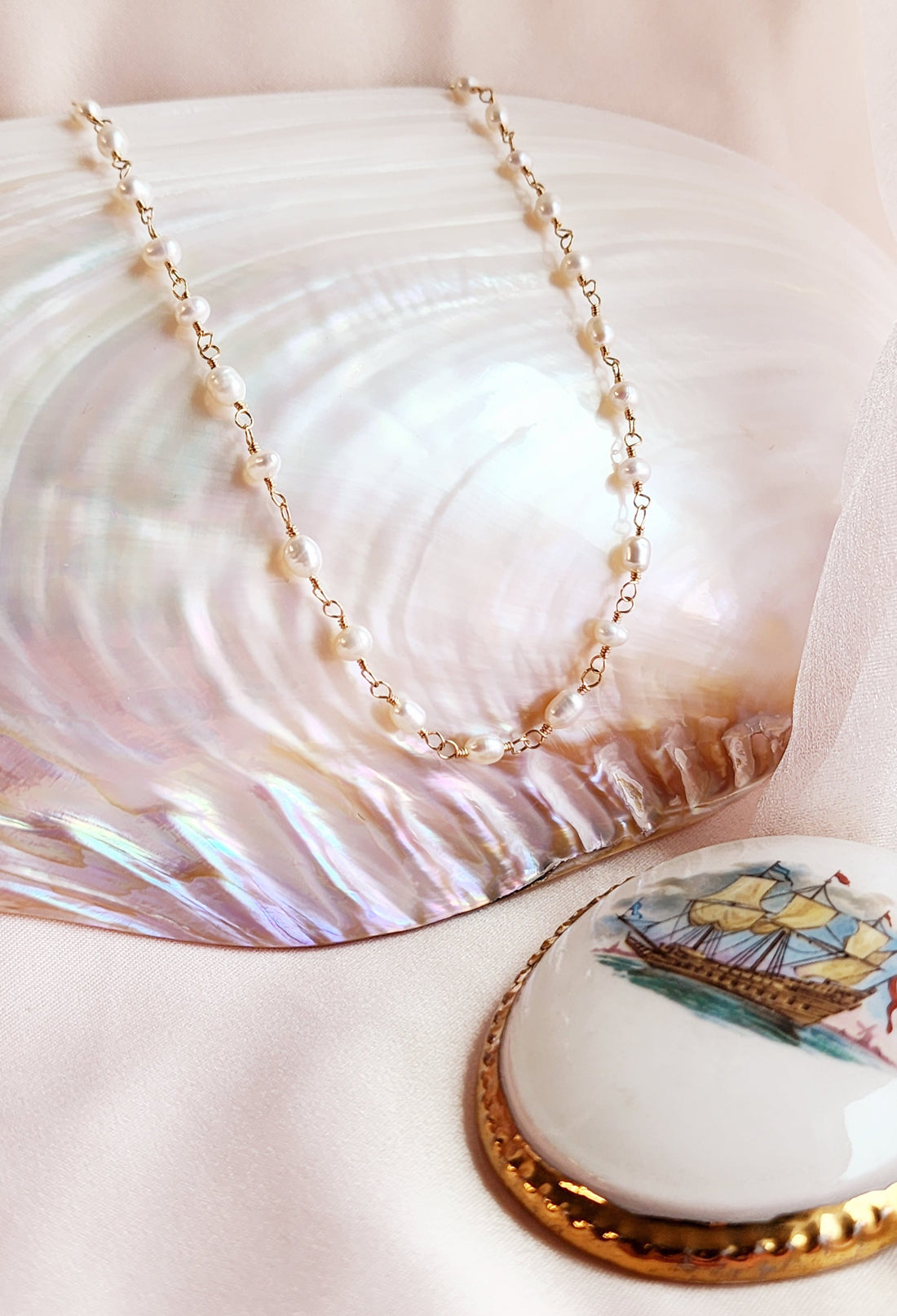 Front view of a hand-linked medium pearl necklace, designed with an enchanting, whimsical style for both everyday wear and bridal looks.