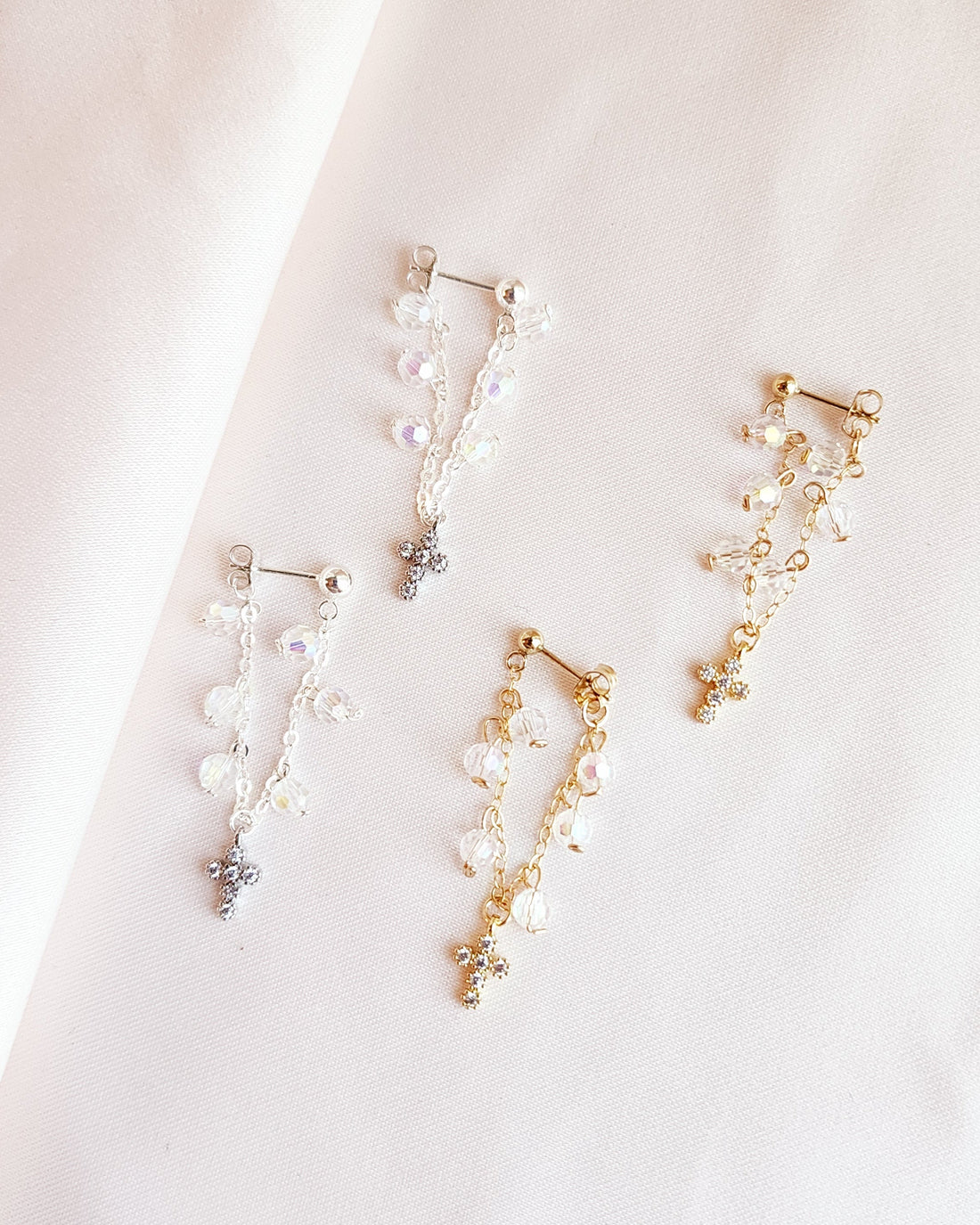 Romantic stud earrings with layering of crystals for a dreamy, dramatic feel with a dangling cross charm